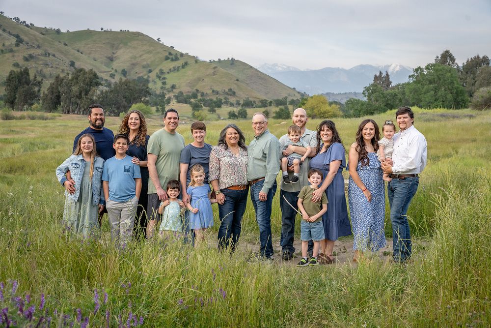 Large family group photo taken in a mountain meadow during summer.