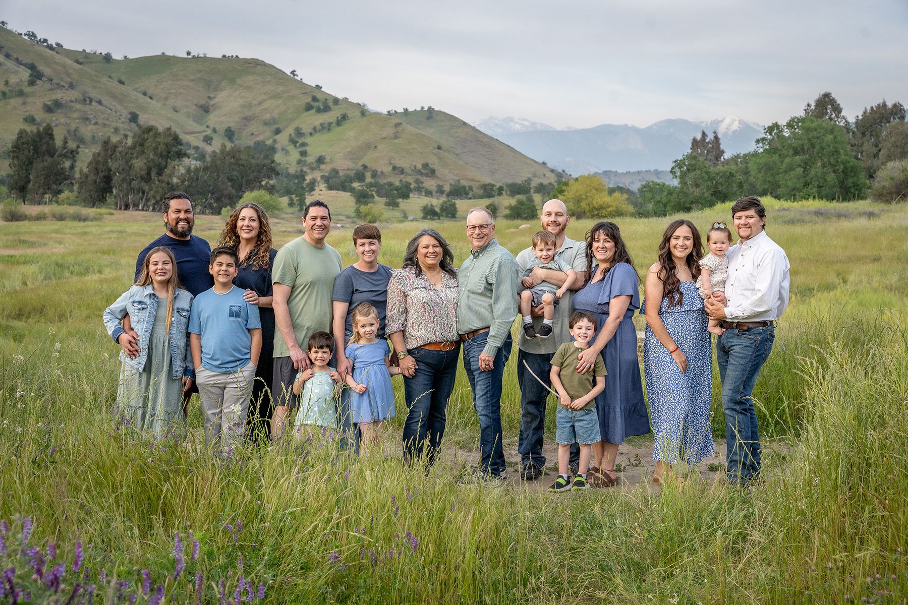 Large family group photo taken in a mountain meadow during summer.
