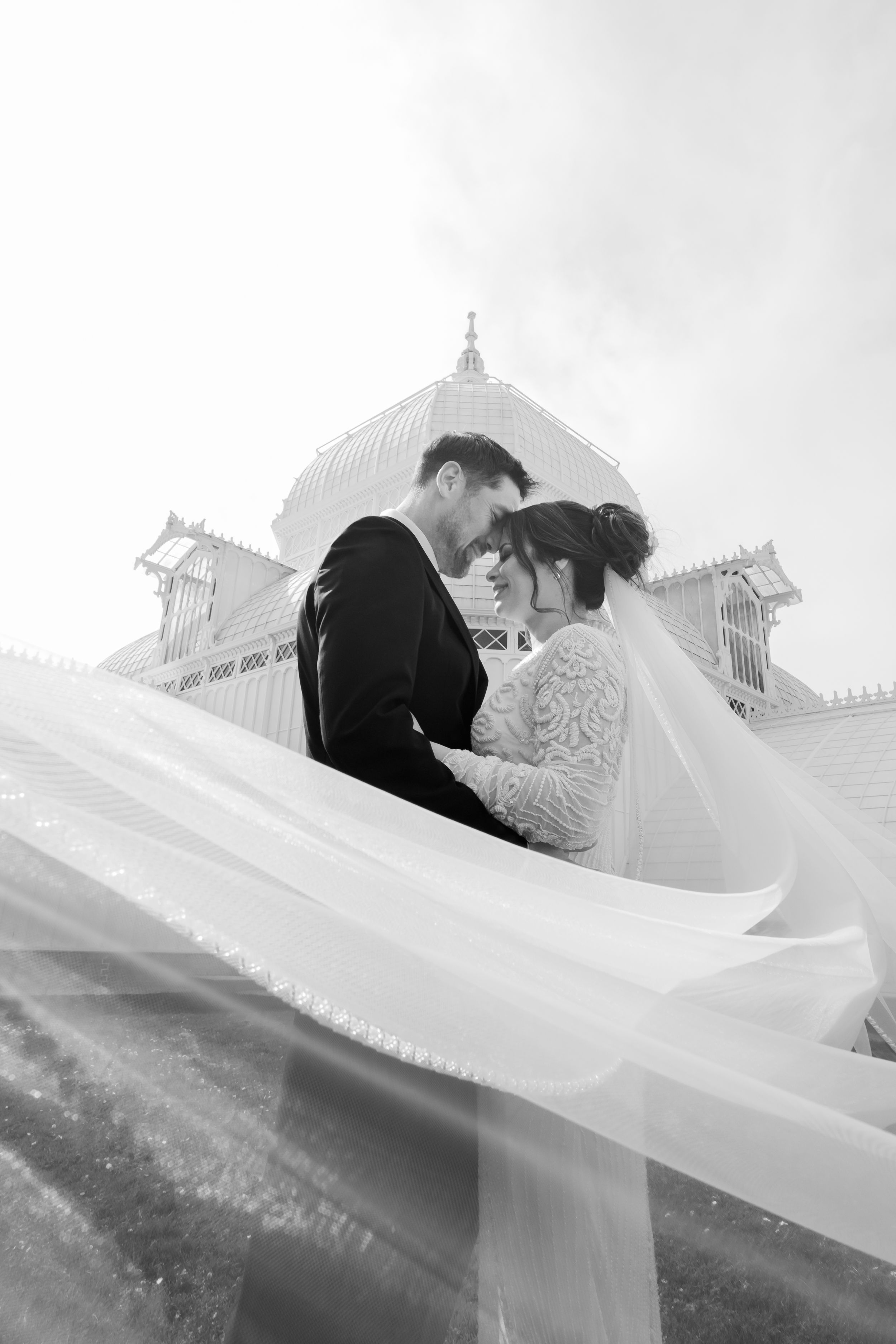 Couple during a post wedding photo shoot at the conservatory of flowers. Groom and Bride with veil.