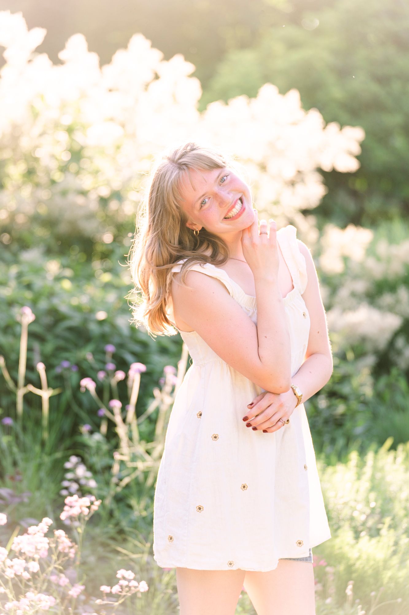 Golden hour senior portrait of a high school girl posing in a sunlit garden at Noerenberg Gardens in Wayzata, Minnesota, with soft sunset