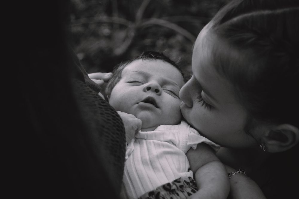 big sister kissing ltitle sister on the cheek