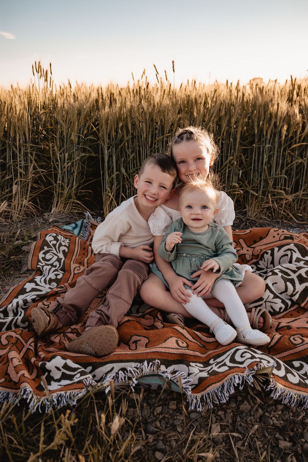 siblings cuddling on rug