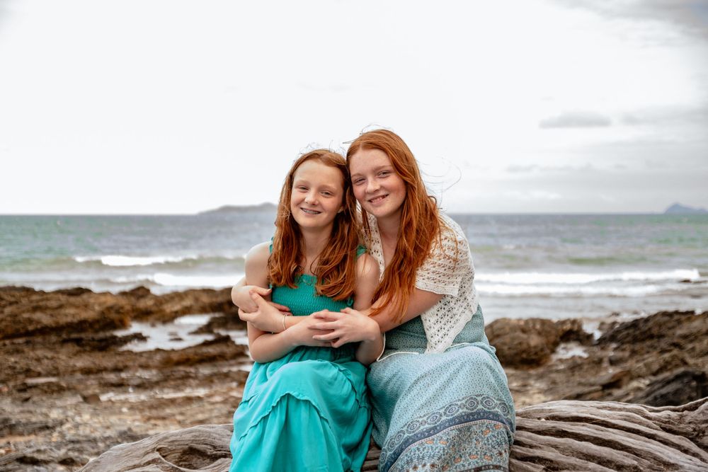 Sisters hugging on the beach