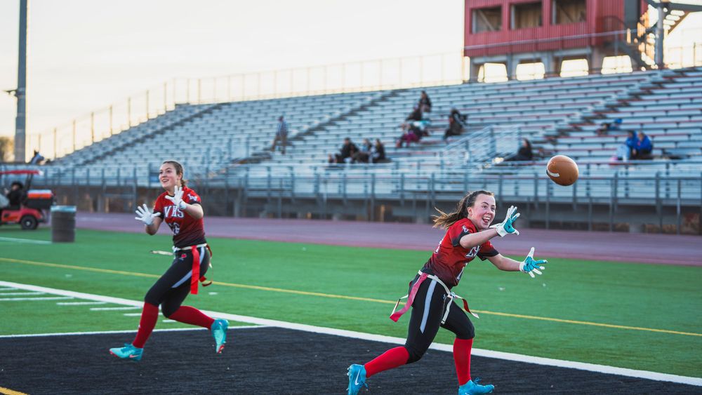 Girls flag football players making catches at the same time