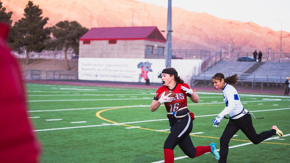 Girls flag football player running off left frame