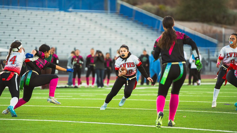 Girls flag football player running straight at the camera