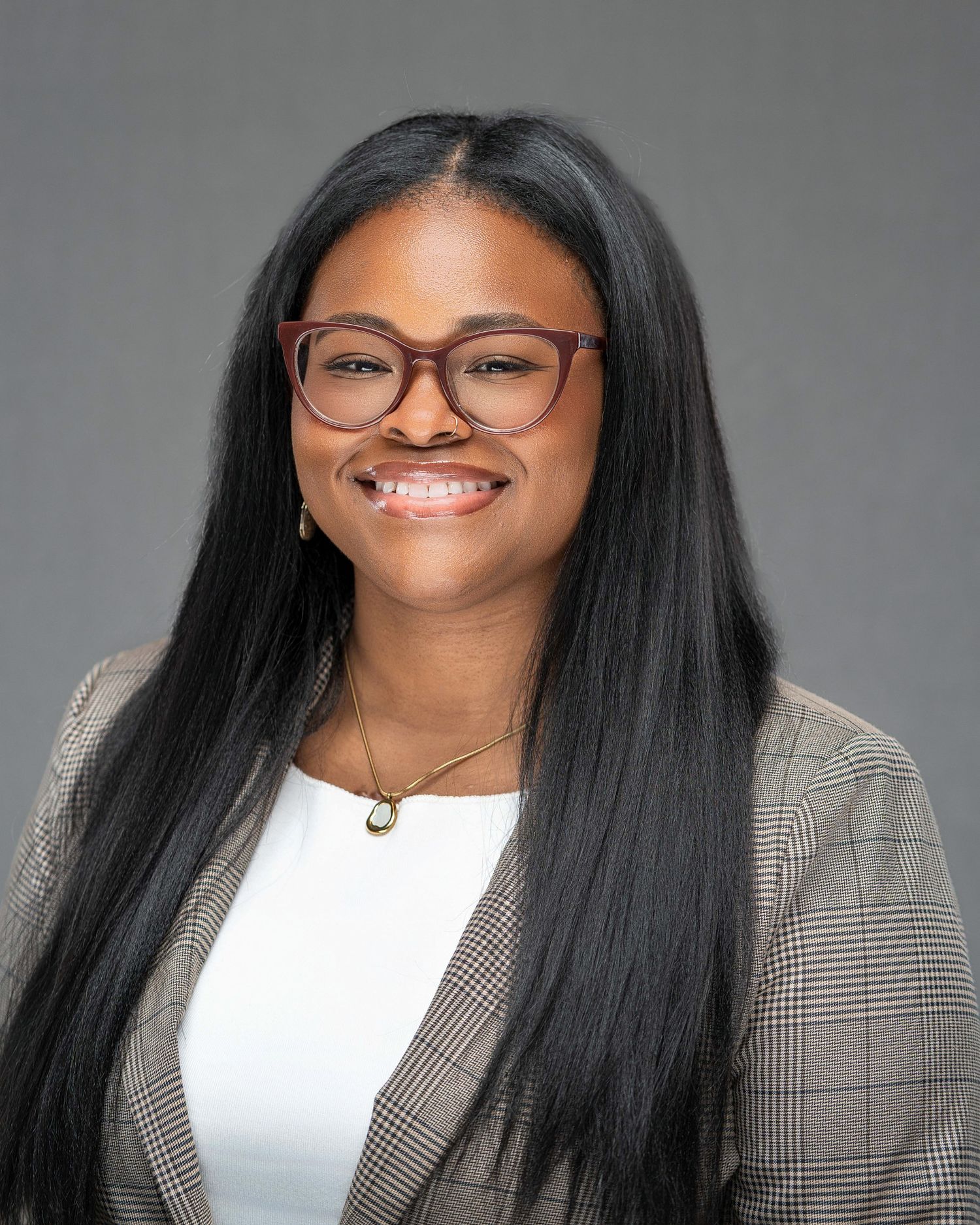 Professional headshot series with black-rimmed glasses and bright smile against gray backdrop.