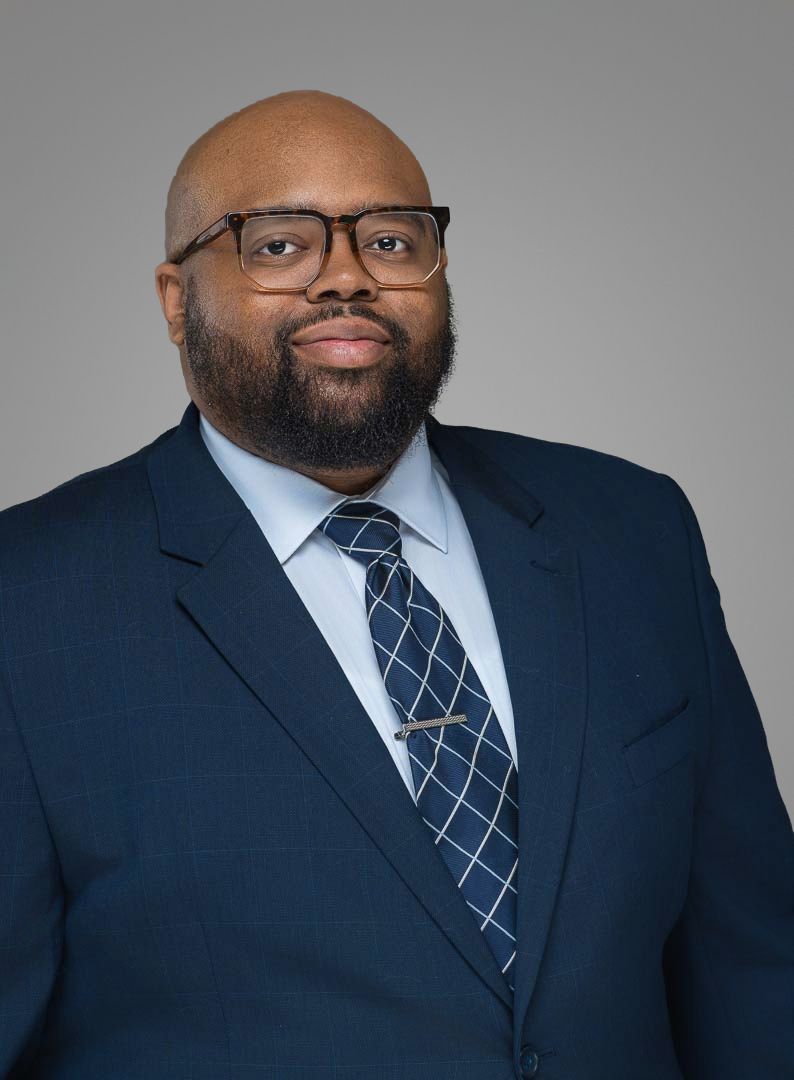Professional headshot series of person in navy suit and striped tie against dark background.