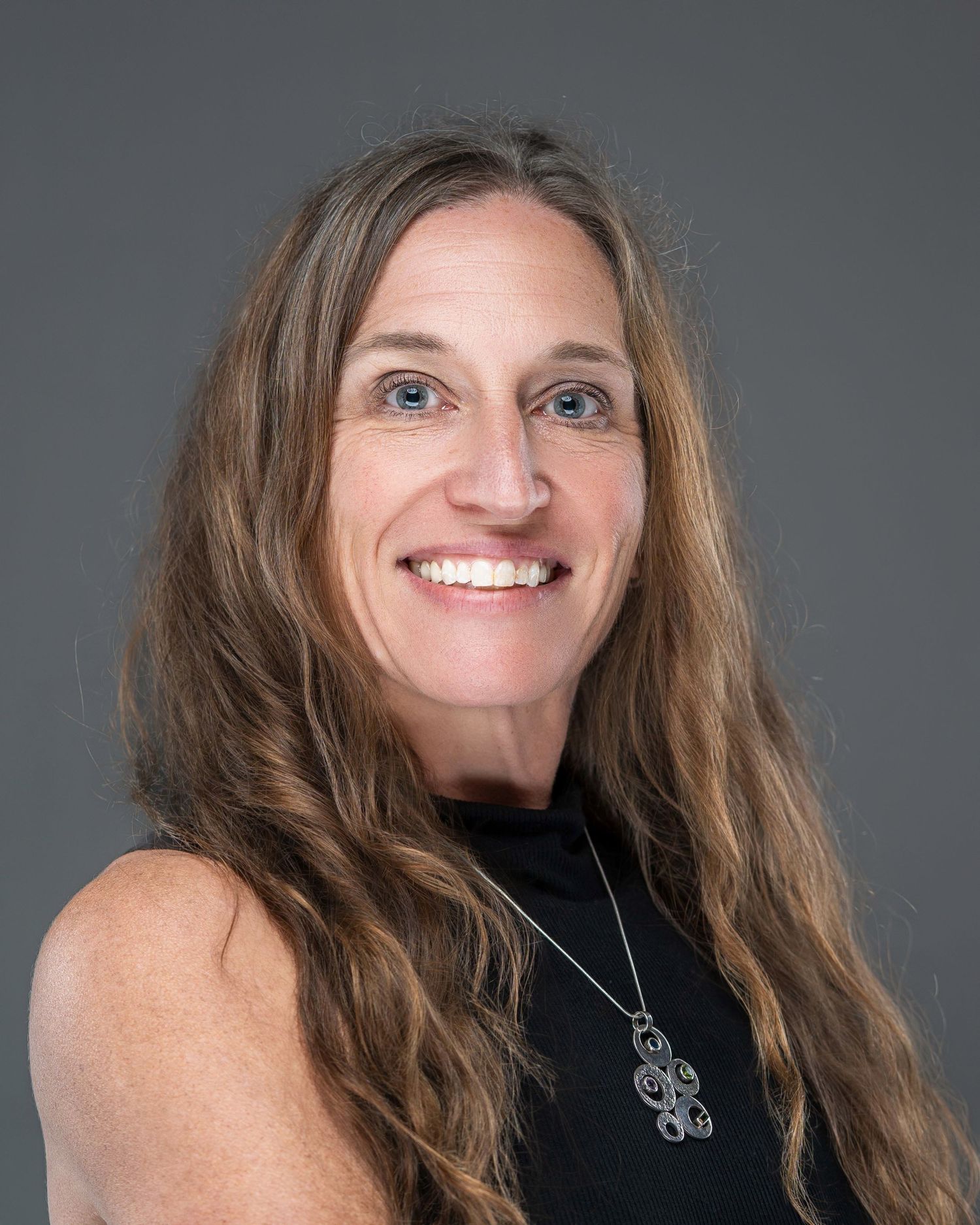 Professional headshot series showing warm smiles and long brown hair against a gray background.