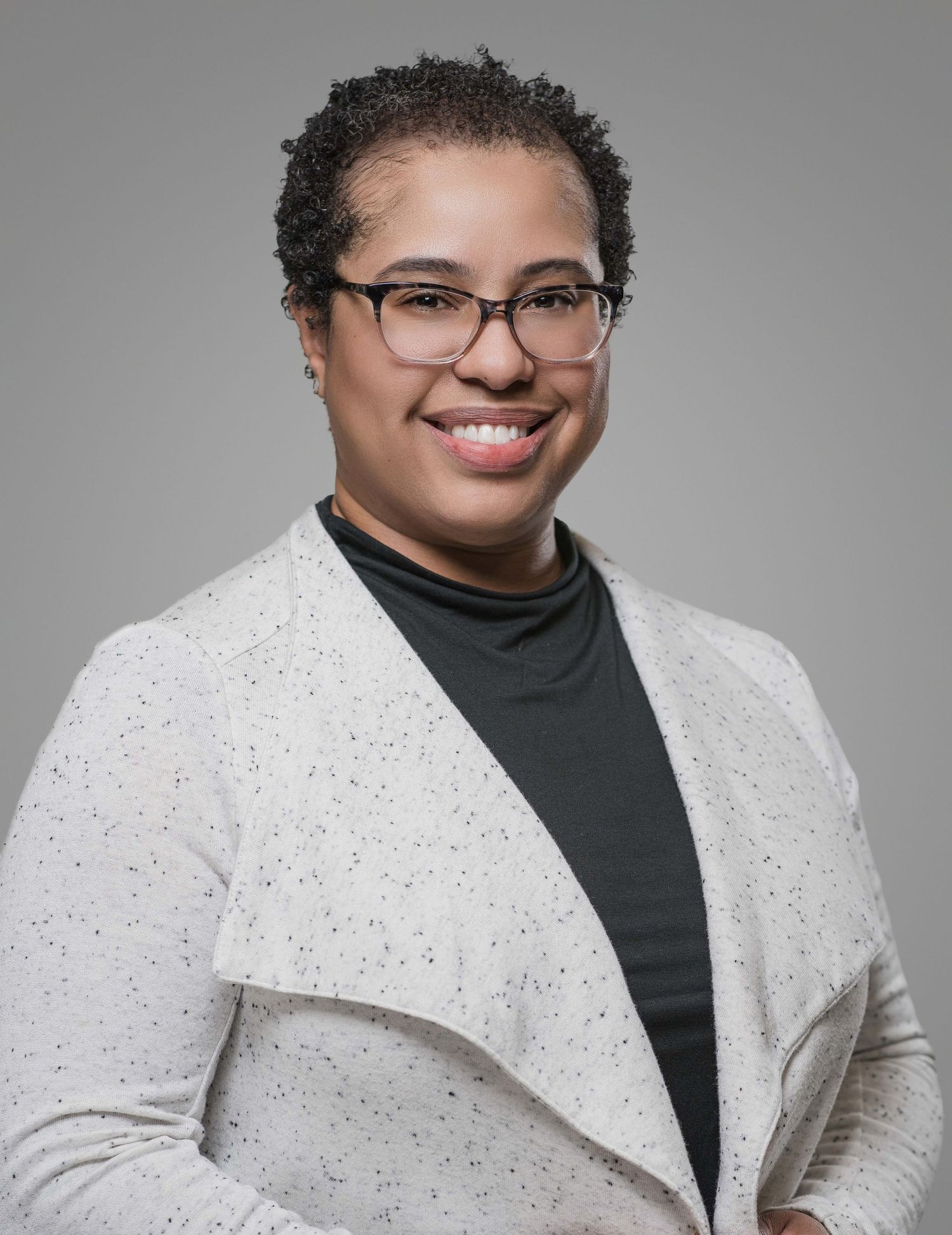 Professional portrait series showing person in white textured jacket against gray background.