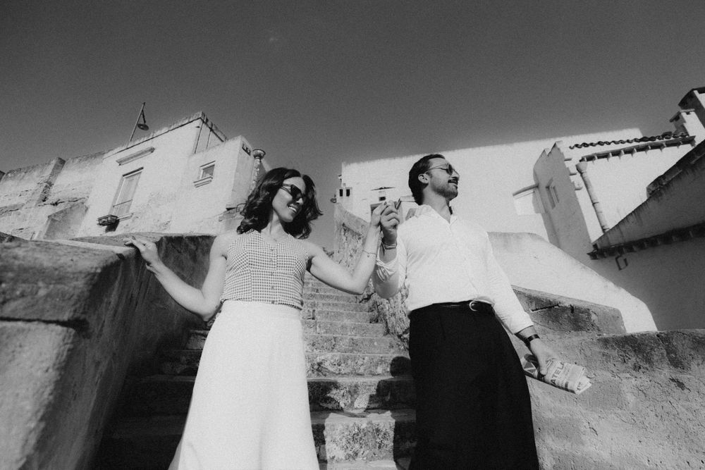 A dynamic black and white photo sequence showing movement as people interact with a curved white wall or structure.
