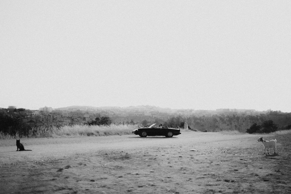 Desert landscape with people silhouetted against a bright empty horizon.