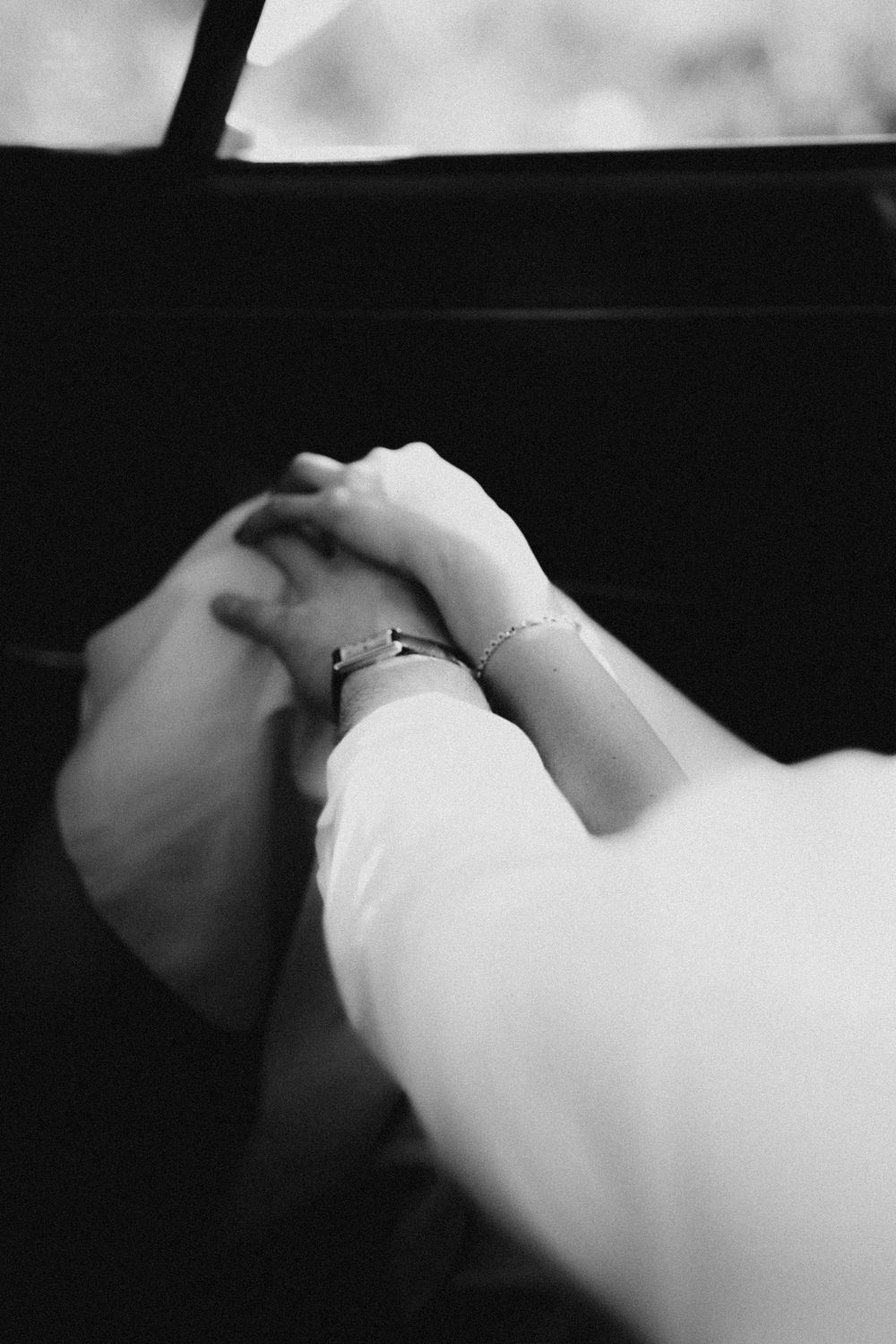 A series of intimate black and white close-up shots showing hands gently touching in artistic composition.