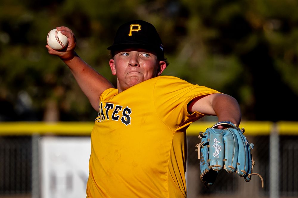 Young Pirates baseball pitcher in gold uniform throwing a ball during practice.