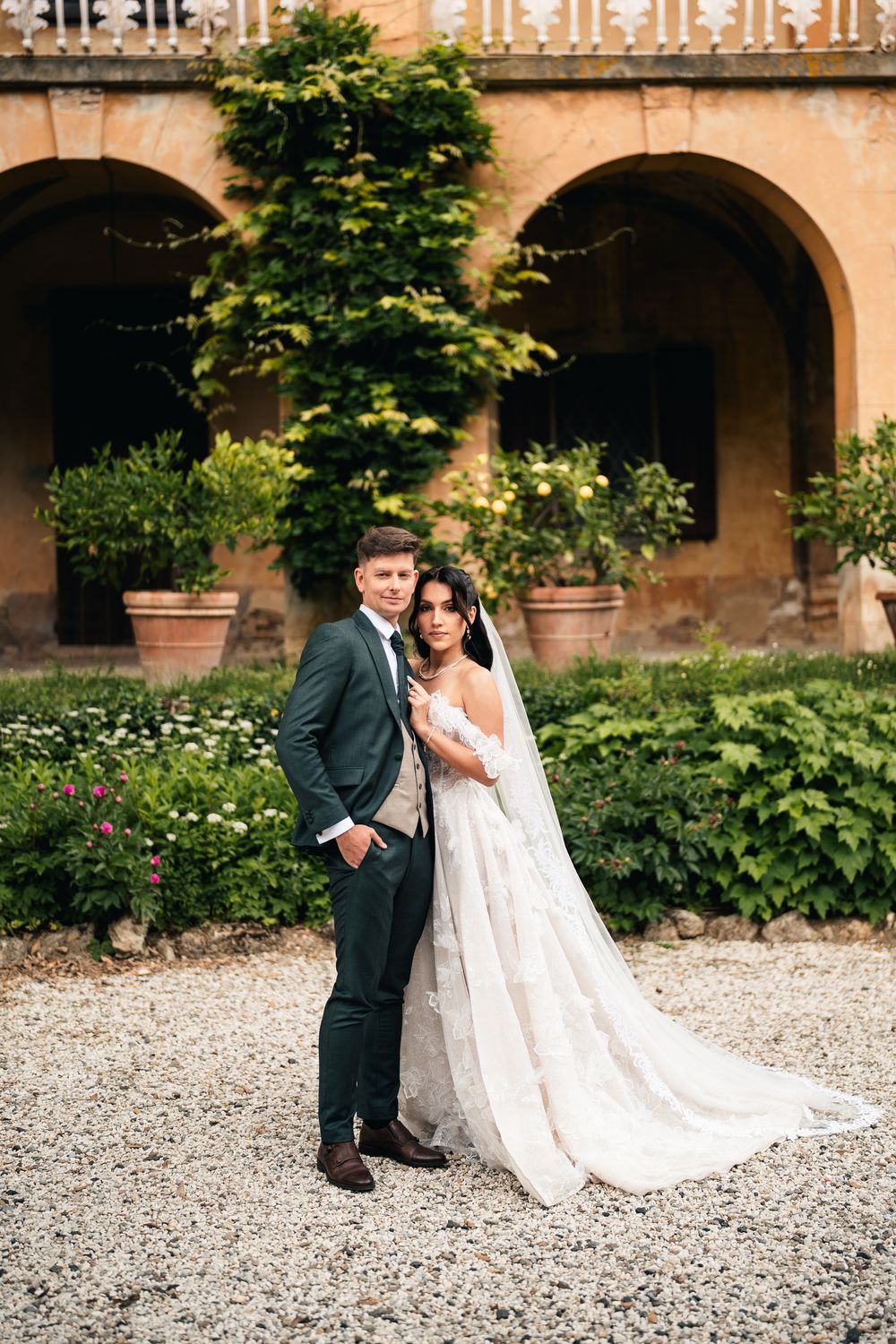 Romantyczne pozowane ujęcie w ogrodach willi, luksusowa sesja poślubna Toskania, fotograf ślubny Włochy.