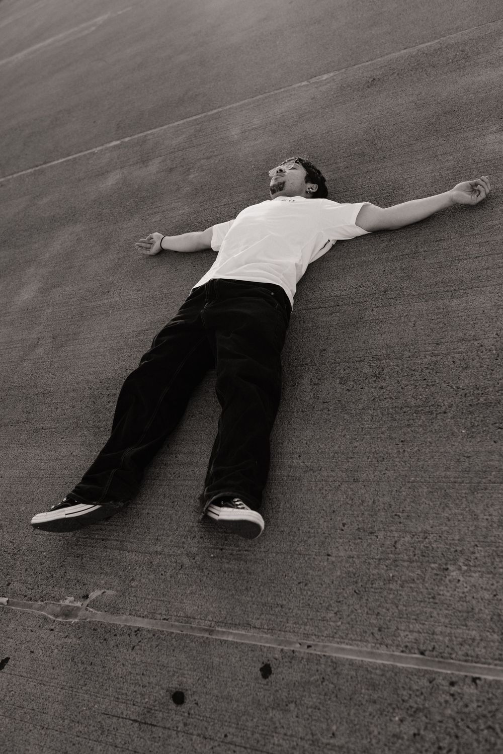 Person lying down on concrete surface in artistic black and white composition in Frederick Maryland
