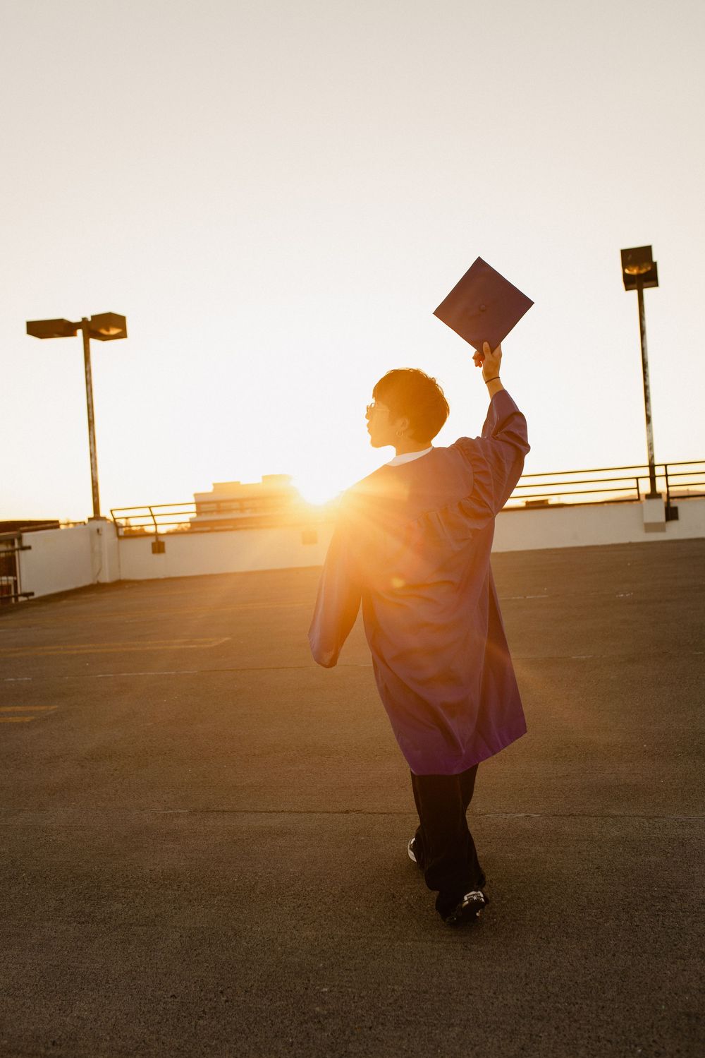 Silhouetted graduate performs joyful movements against sunset sky in Frederick Maryland