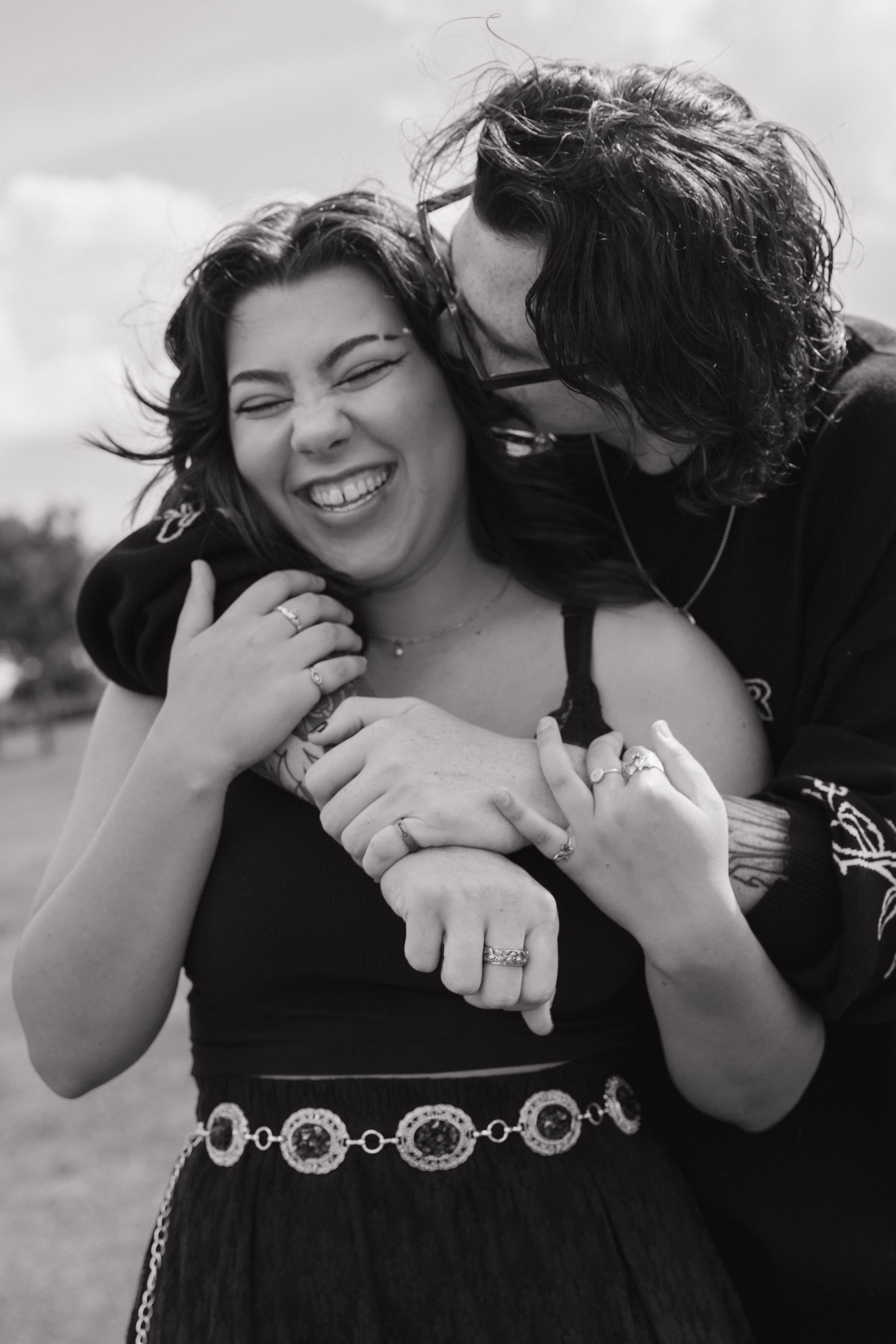 Black and white photo series showing joyful moments and laughter between a couple.