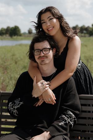 Couple sharing affectionate moments while sitting on a park bench outdoors.
