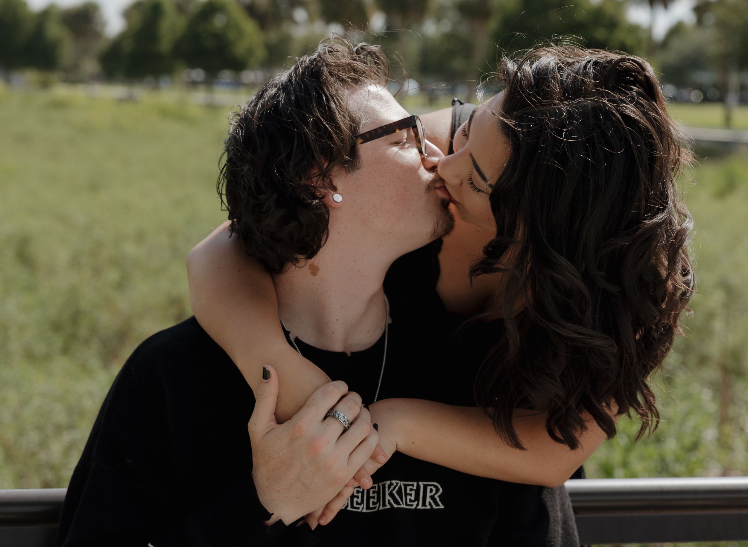 A tender romantic moment shared between a couple in a park setting.