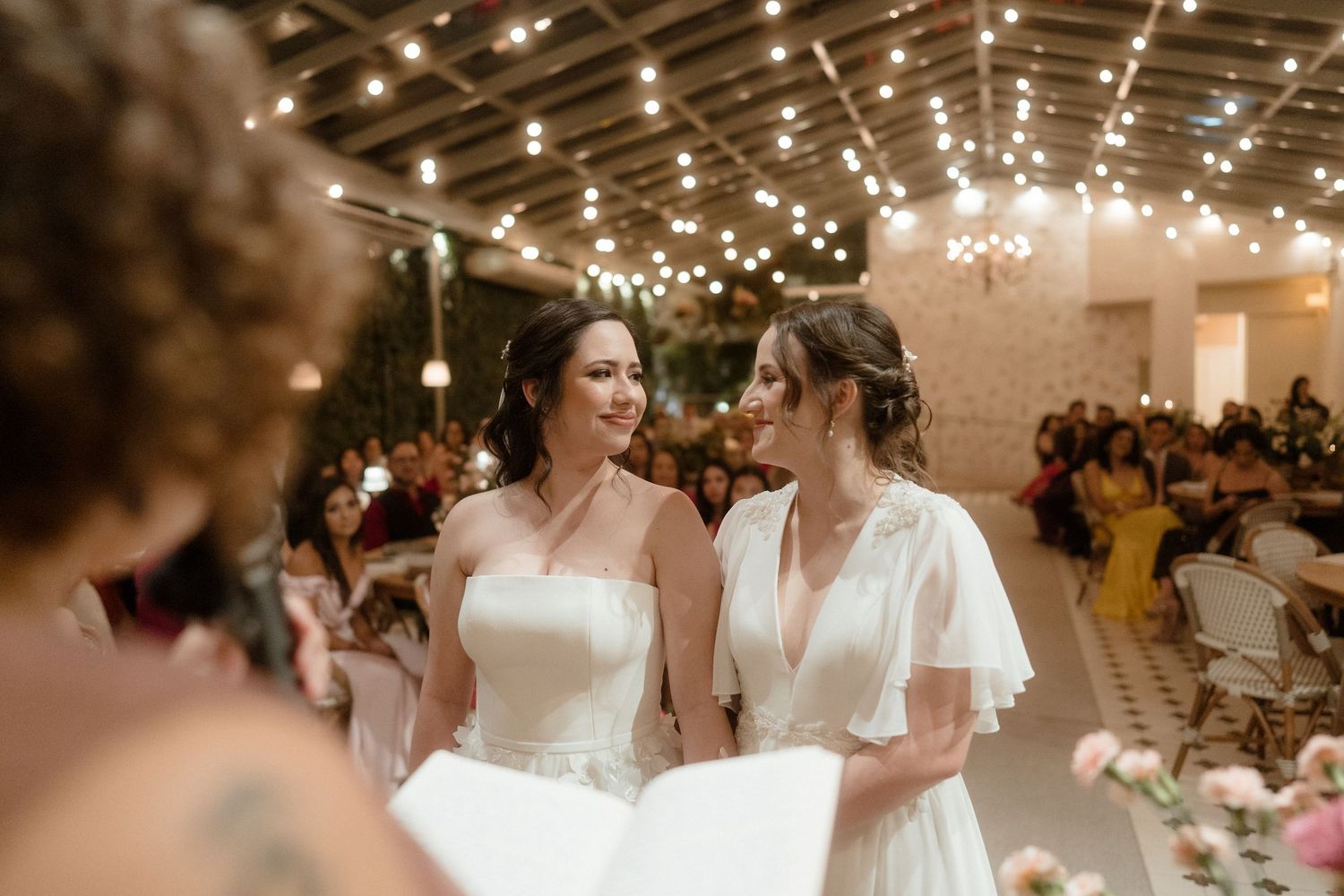 An elegant indoor wedding reception with glowing string lights creating a magical atmosphere.