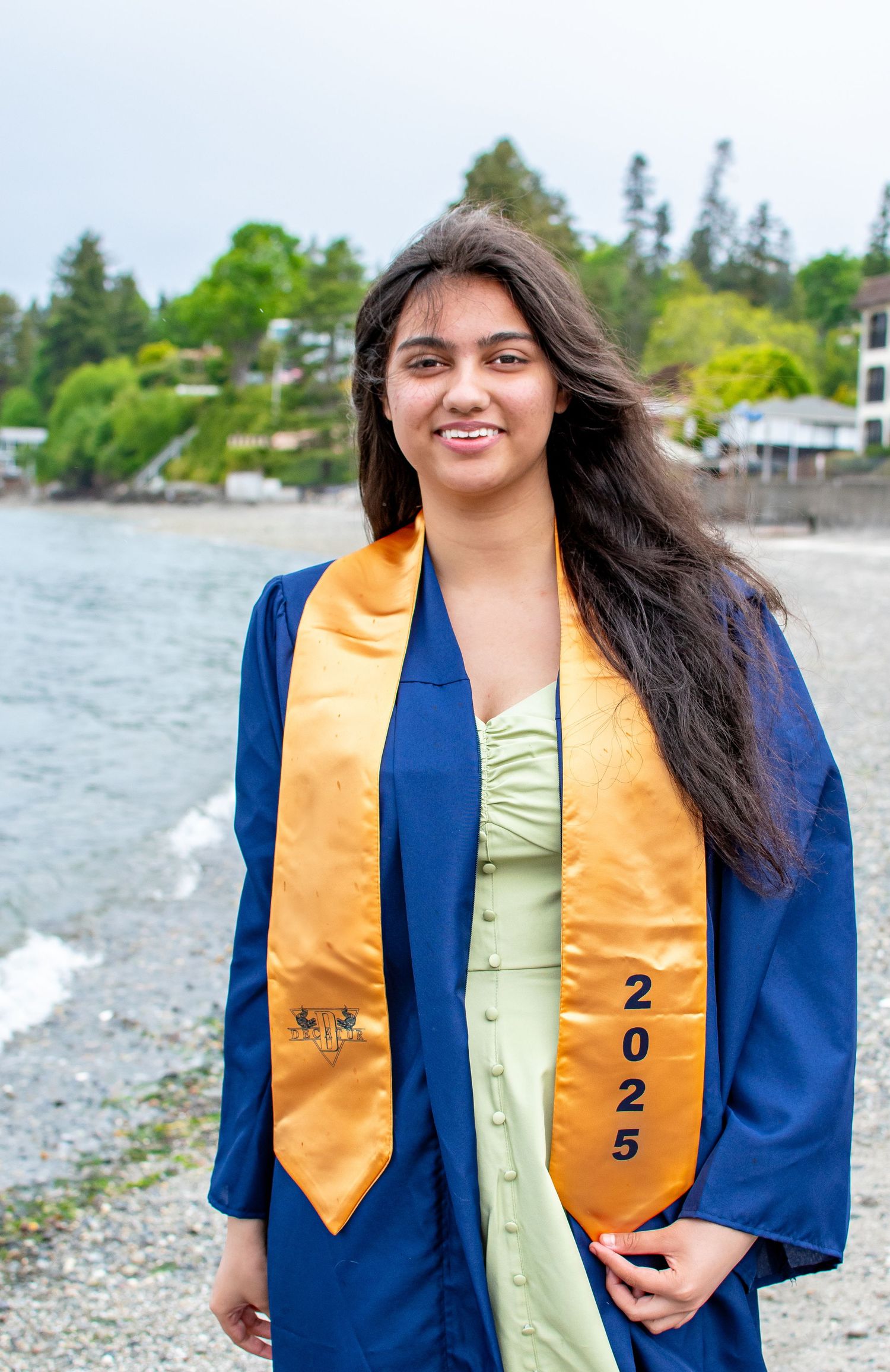 Senior portrait in cap and gown on the beach at Redondo Park, celebrating the Class of 2025 in Federal Way, Washington.
