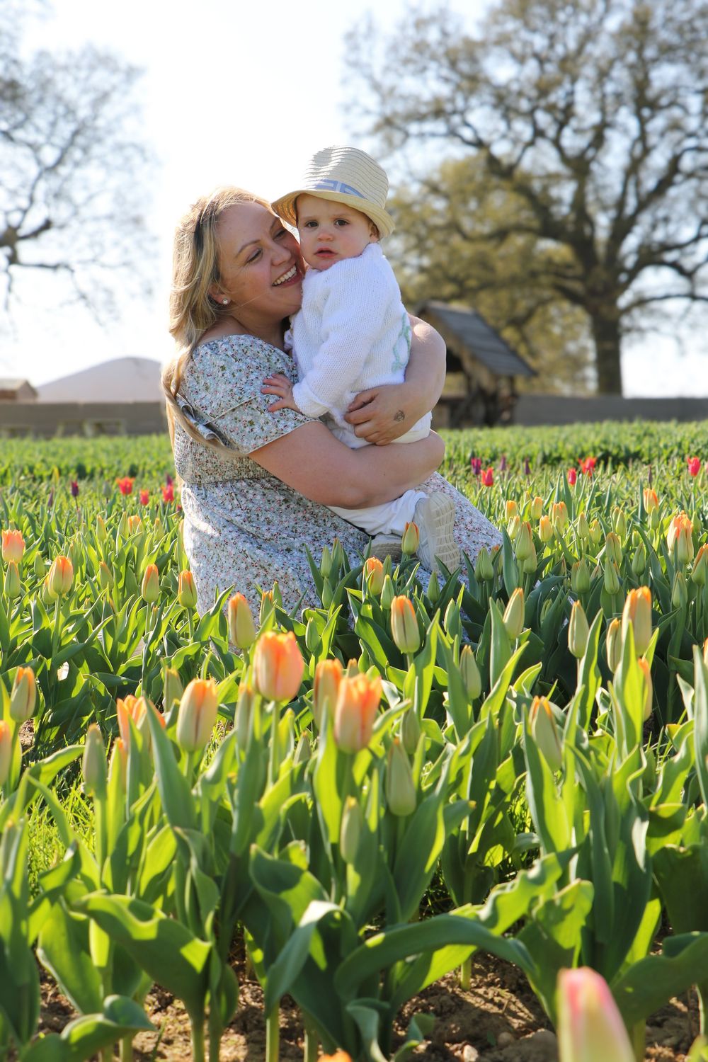 Tender moment captured in a tulip field with bright flowers blooming all around.