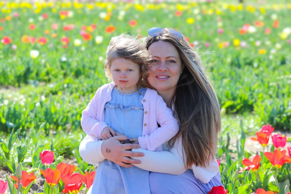 Springtime portrait in a field of colorful tulips on a bright sunny day.