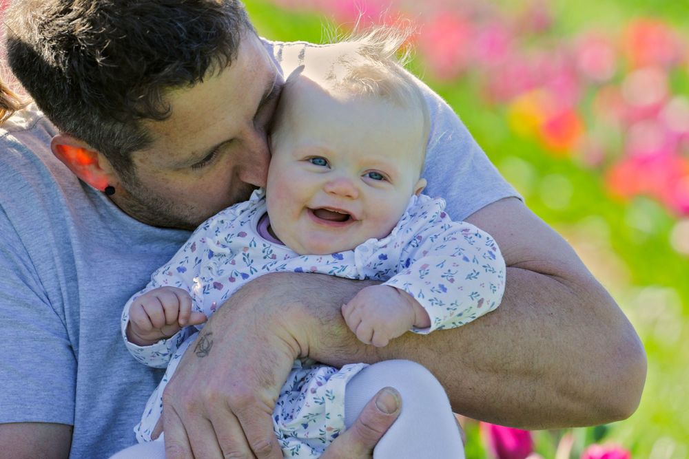 Sweet moment captured between family members in a colorful flower garden.