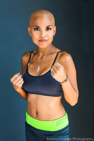 Athletic figure in workout attire strikes confident pose against blue background.