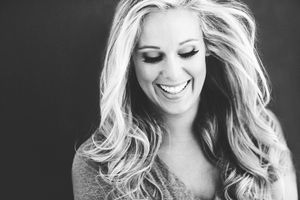 Black and white portrait capturing joyful laughter and flowing blonde hair.