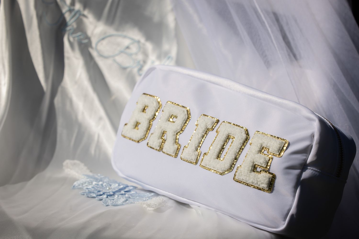White embroidered robe or garment detail with golden text against a light background.