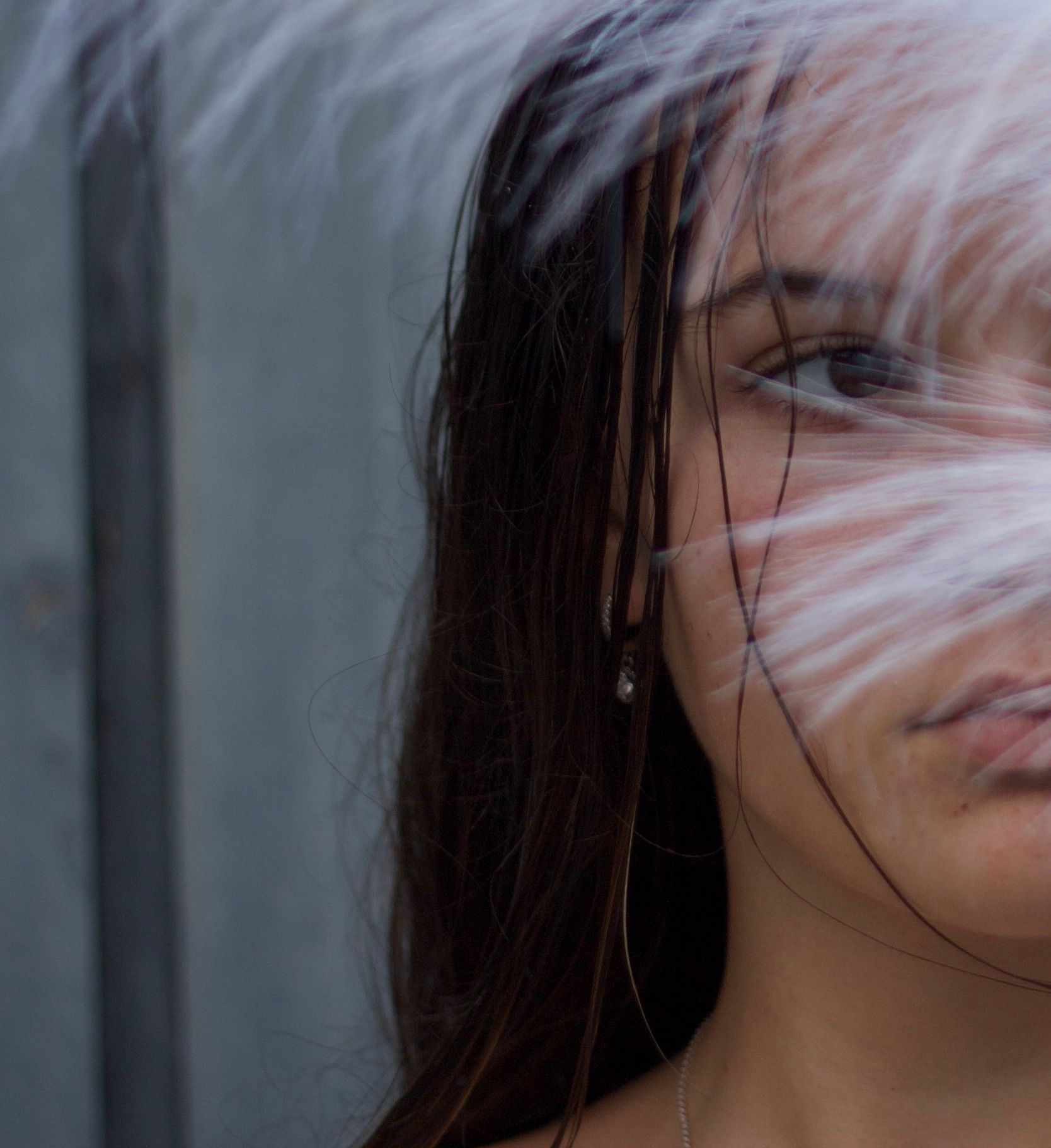 Artistic portrait showing half of a person's face in dramatic lighting.