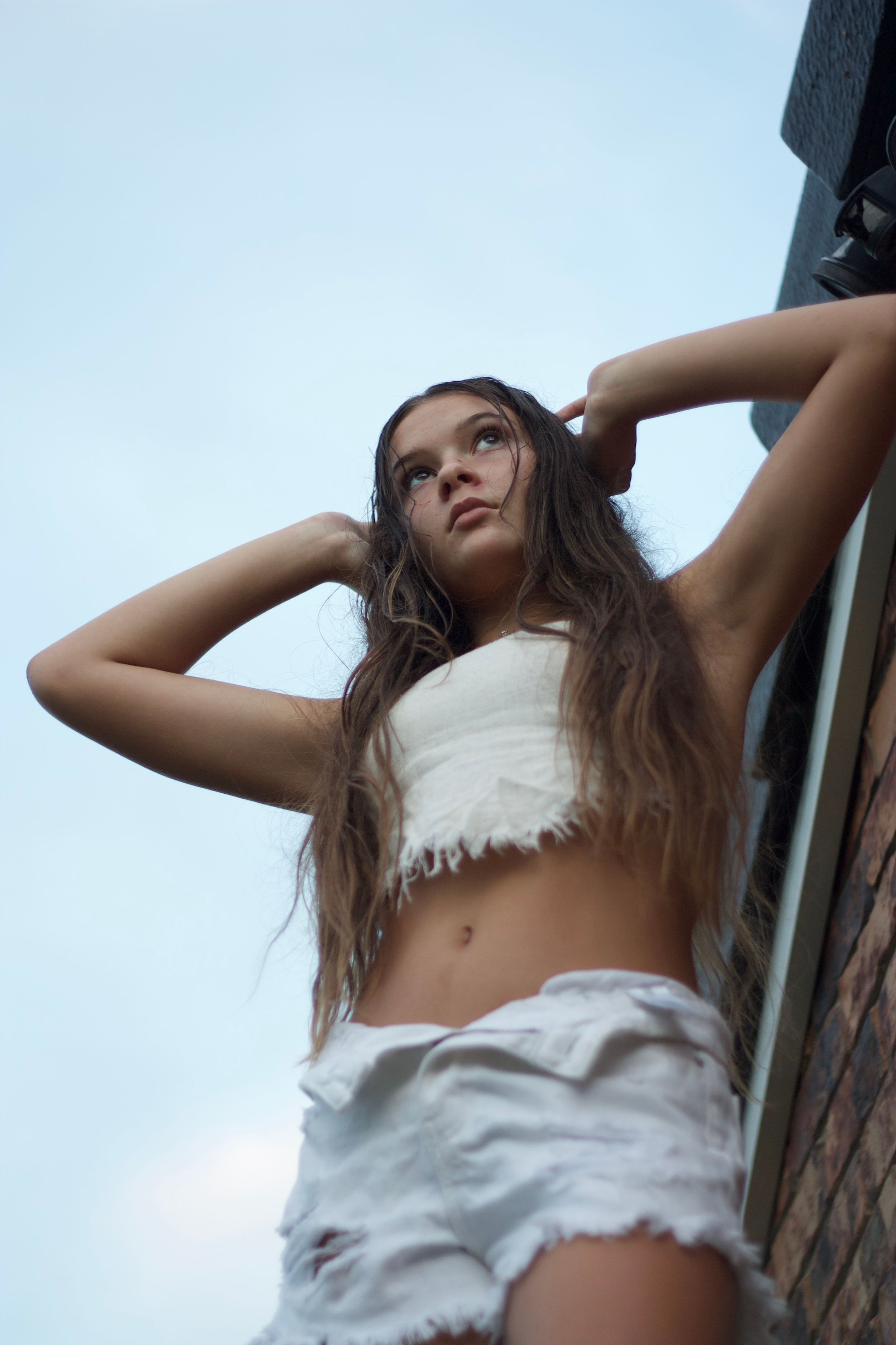 Low angle shot of someone in white clothing against a light blue sky.