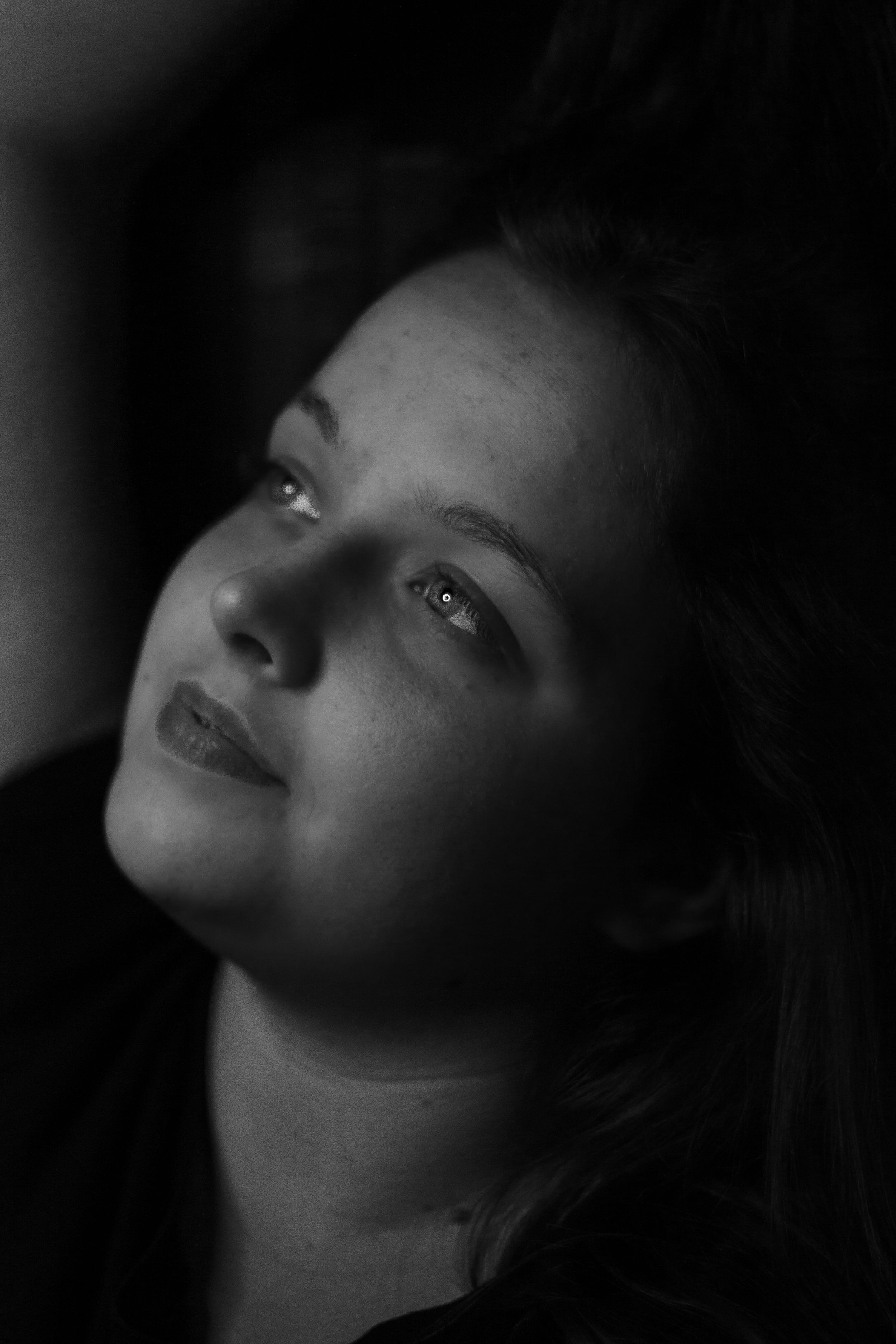 Moody black and white portrait with dramatic shadows and lighting.