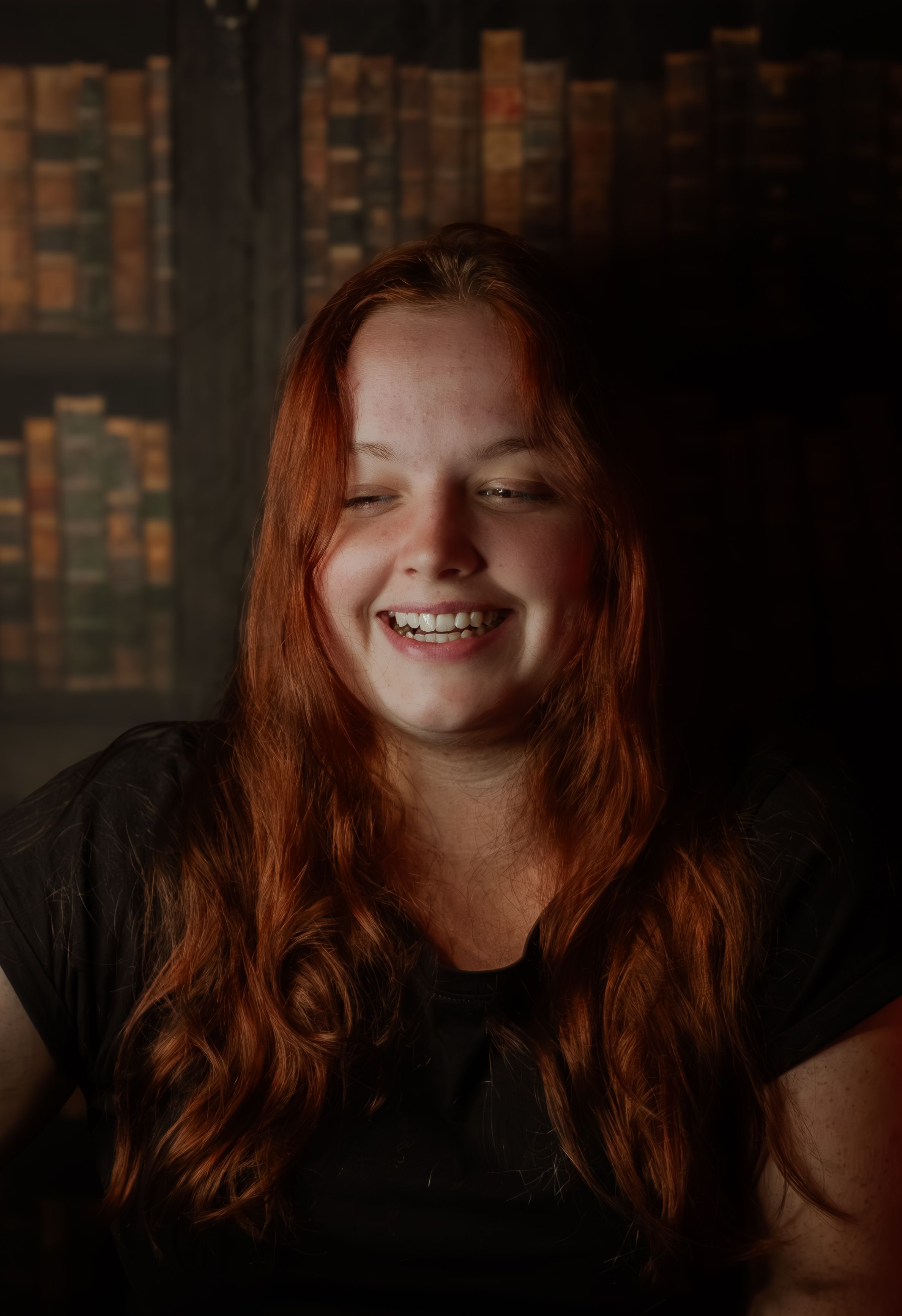 Portrait in warm lighting showing a joyful expression and natural red hair.