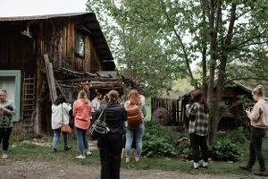 Wedding guests gather outside rustic barn venue during celebration.