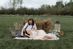 Romantic picnic setup with pampas grass decorations in a green meadow.