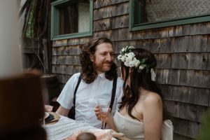 An intimate outdoor dining scene with rustic decor against a weathered wood building.