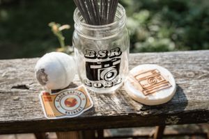 Photography branding materials with a mason jar and wooden coasters on rustic wood surface.
