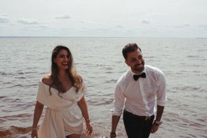 A joyful moment shared between two people in formal wear by the ocean.