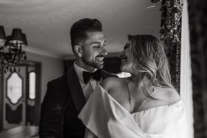 An intimate black and white portrait of a couple dancing in formal attire.