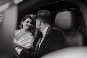 Black and white portrait of couple sharing tender moment in car interior.