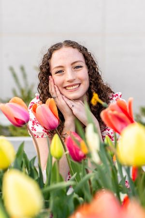 A girl posing amidst vibrant blooms at mount timpanogos temple in American Fork, Utah.