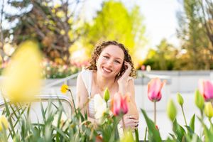 Candid spring portrait amid blooming tulips in a sunny garden setting at mount timpanogos temple in American Fork, Utah.