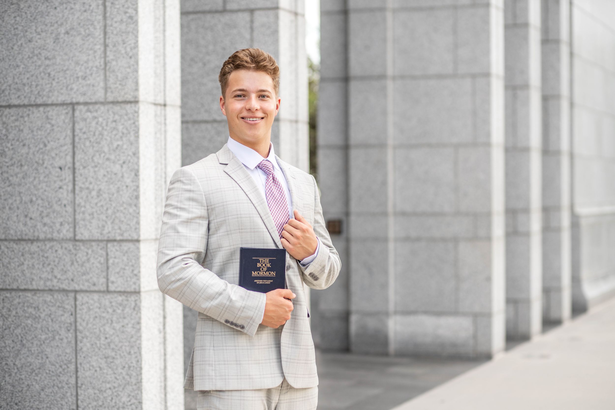 A missionary holding the Book of Mormon at the Draper Utah temple in Draper, Utah.