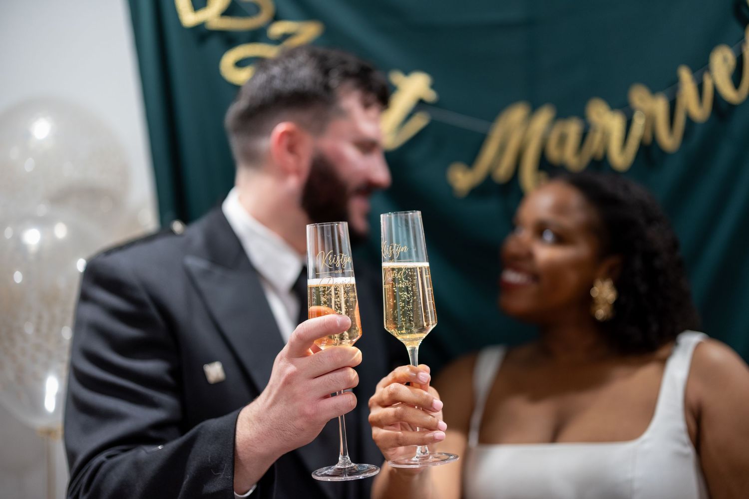 A couple raises champagne flutes to toast during their celebratory wedding moment.