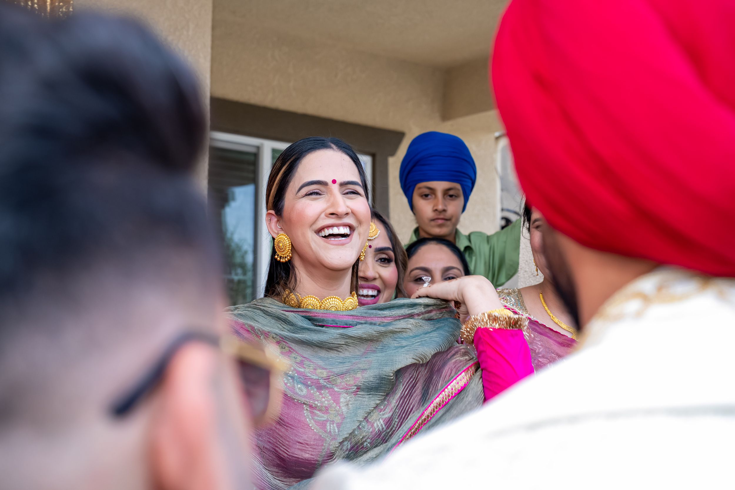 A group celebrates during a festive cultural gathering wearing traditional Sikh attire and headwear.