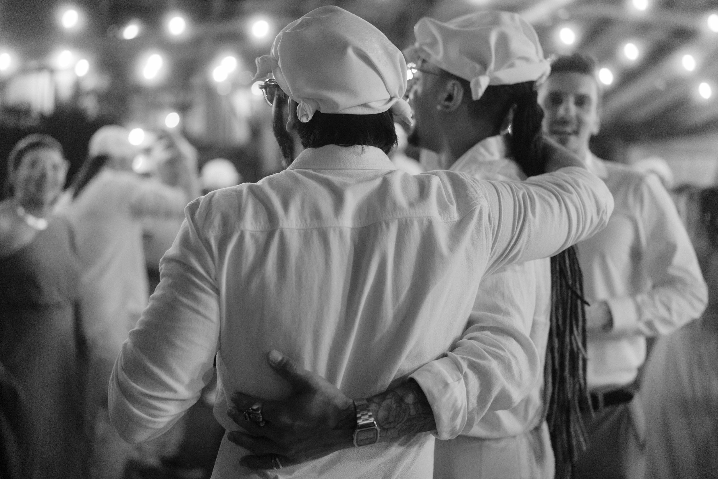 Dancers moving in sync under bright venue lighting at an evening event.