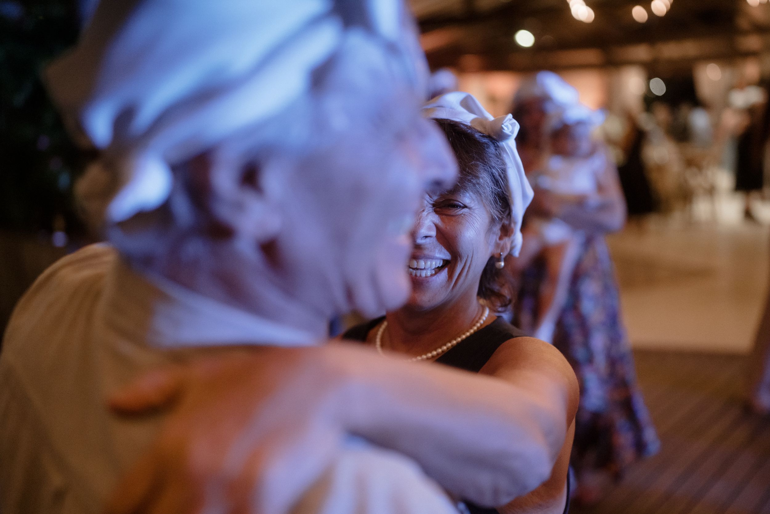 People enjoying themselves at a dimly lit indoor celebration.